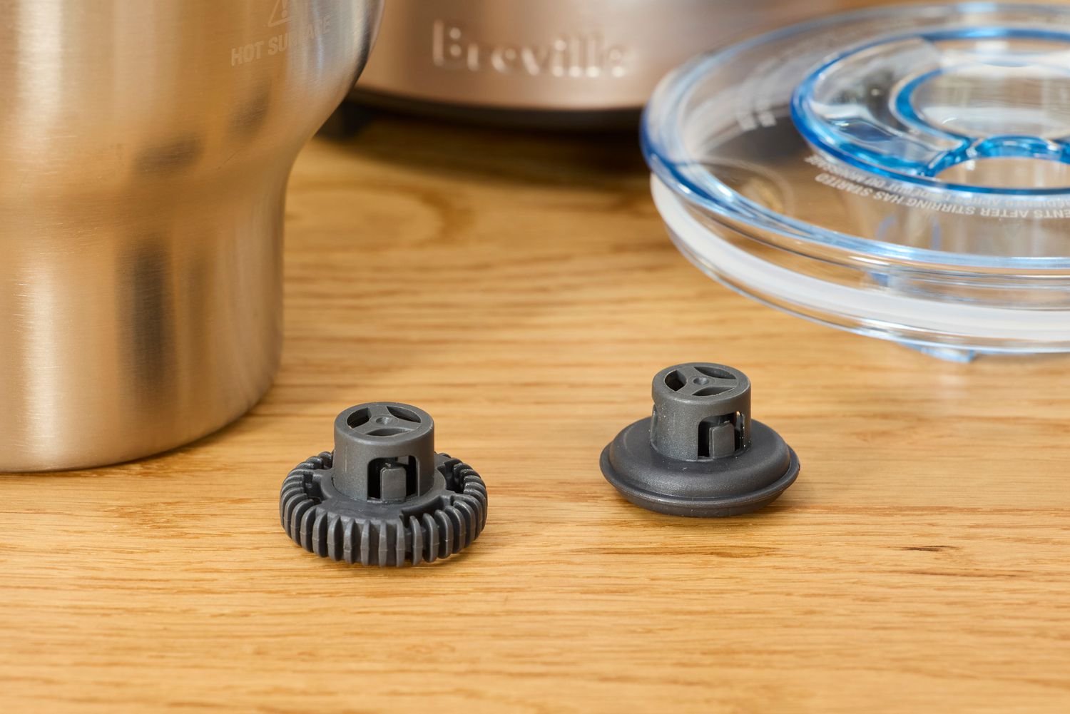 Two milk frother discs on a wooden countertop.
