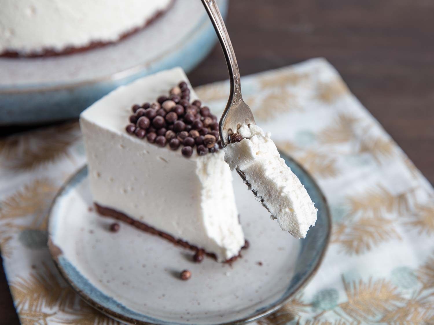 A slice of snowy white, no-bake cheesecake with a bite on a fork.
