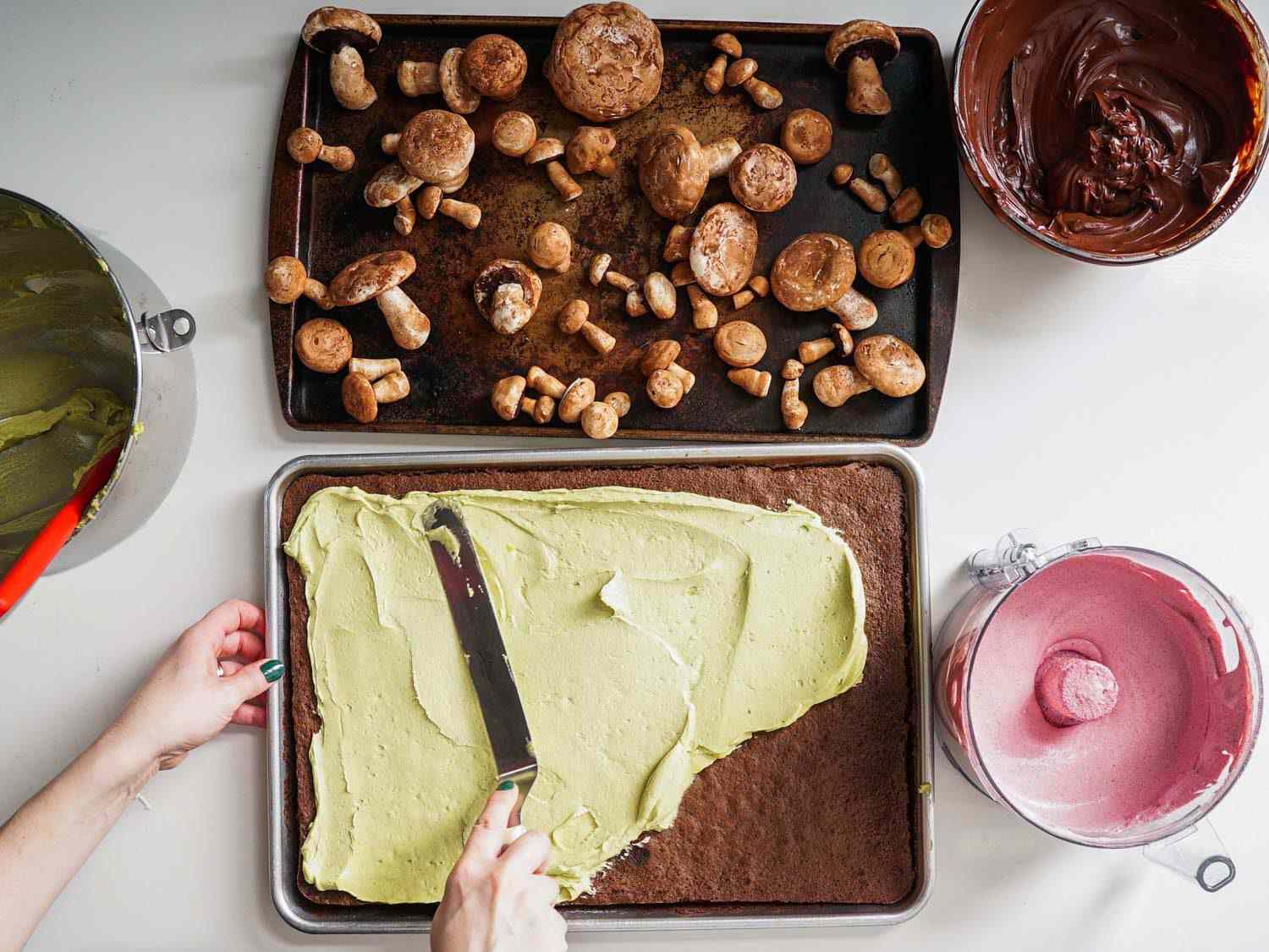 Spreading pistachio buttercream over the cooled cake.