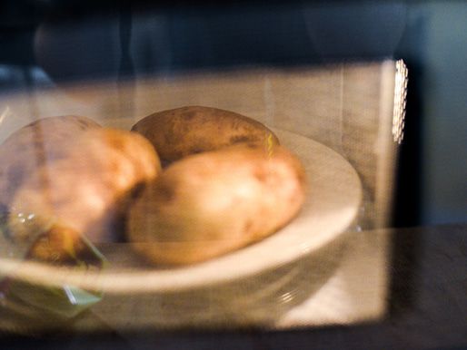 Russet potatoes cooking in a microwave.
