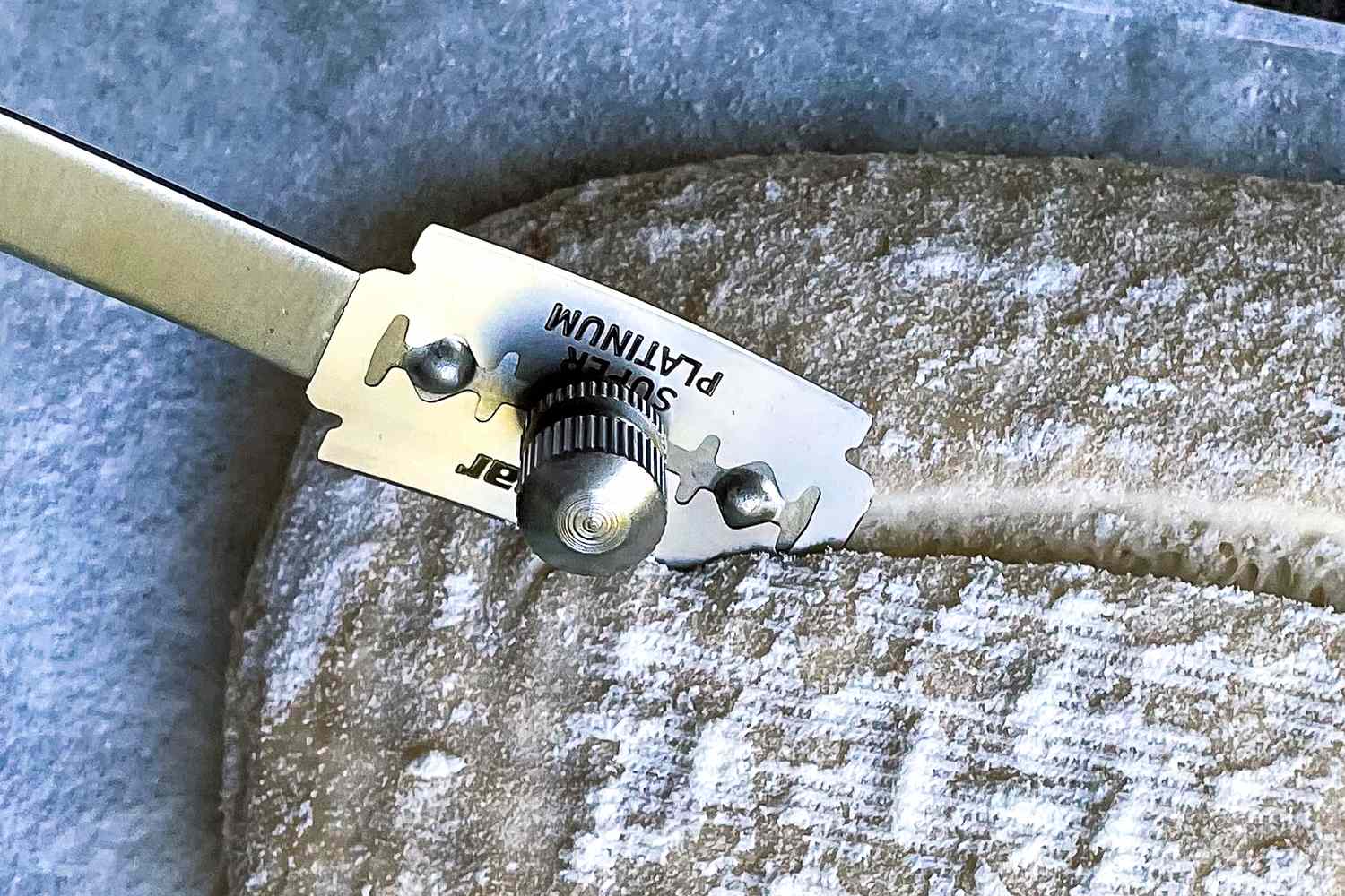 The Baker of Seville bread lame being used to score a loaf of bread