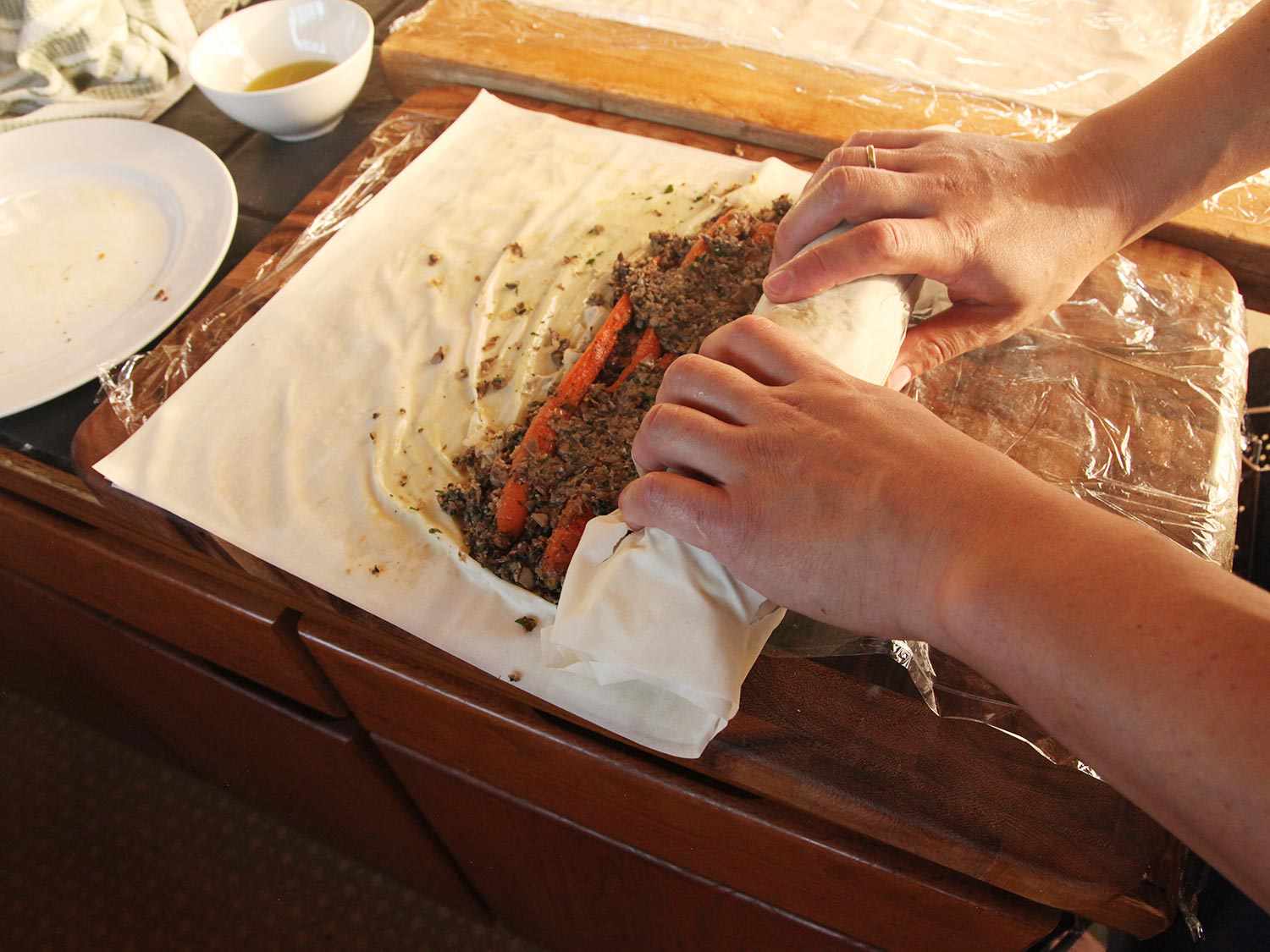 Rolling filled phyllo into a tight cigar shape.