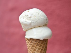 Profile closeup of a double scoop of horchata ice cream stacked into an ice cream cone.