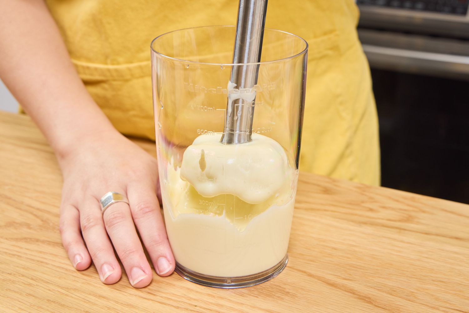A person uses the KitchenAid Go Cordless Hand Blender