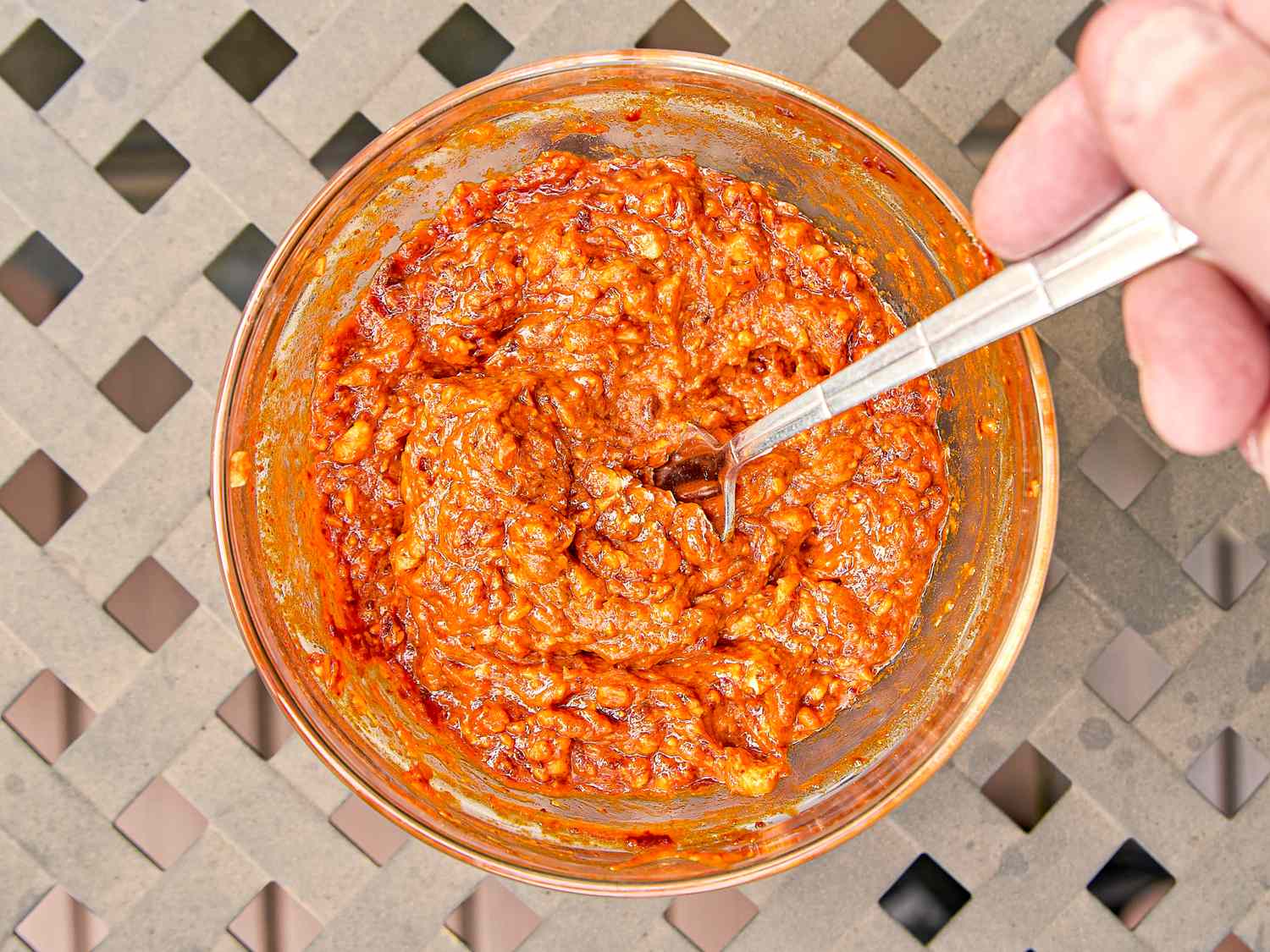 Bowl of smoked paprika and harissa butter being stirred by a spoon