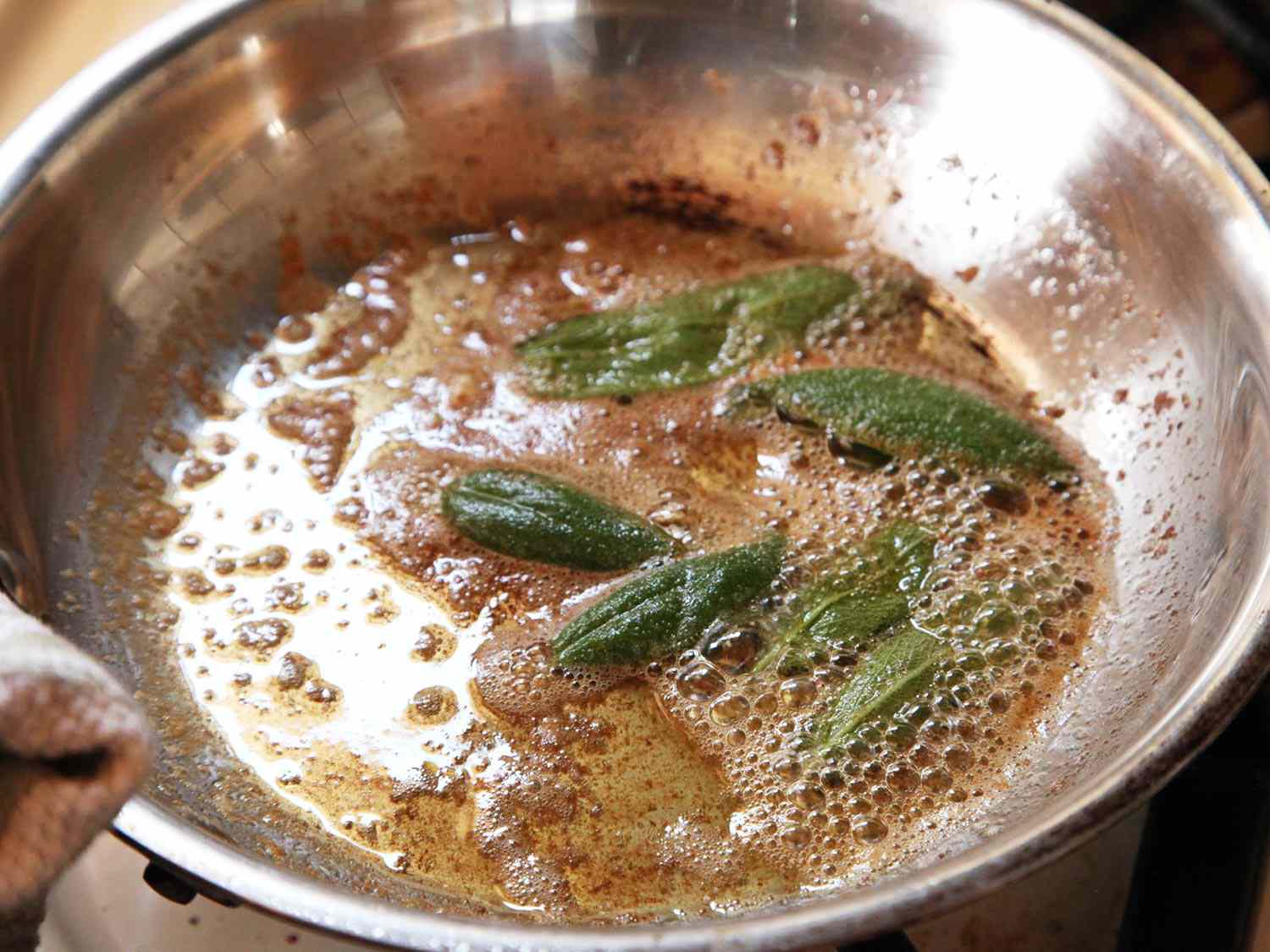 Sage leaves crisping up in brown butter in a skillet. 