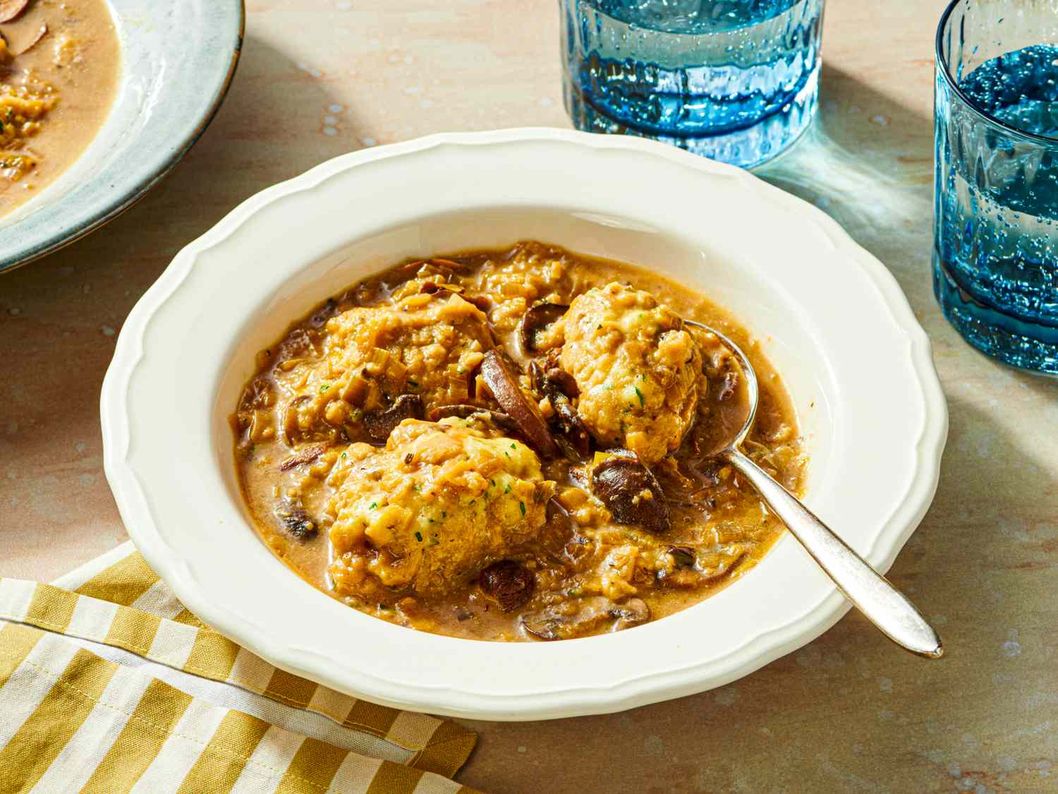 Bowl of mushroom and dumpling soup with a spoon