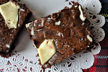 Closeup of a peppermint bark brownie on a paper doily.