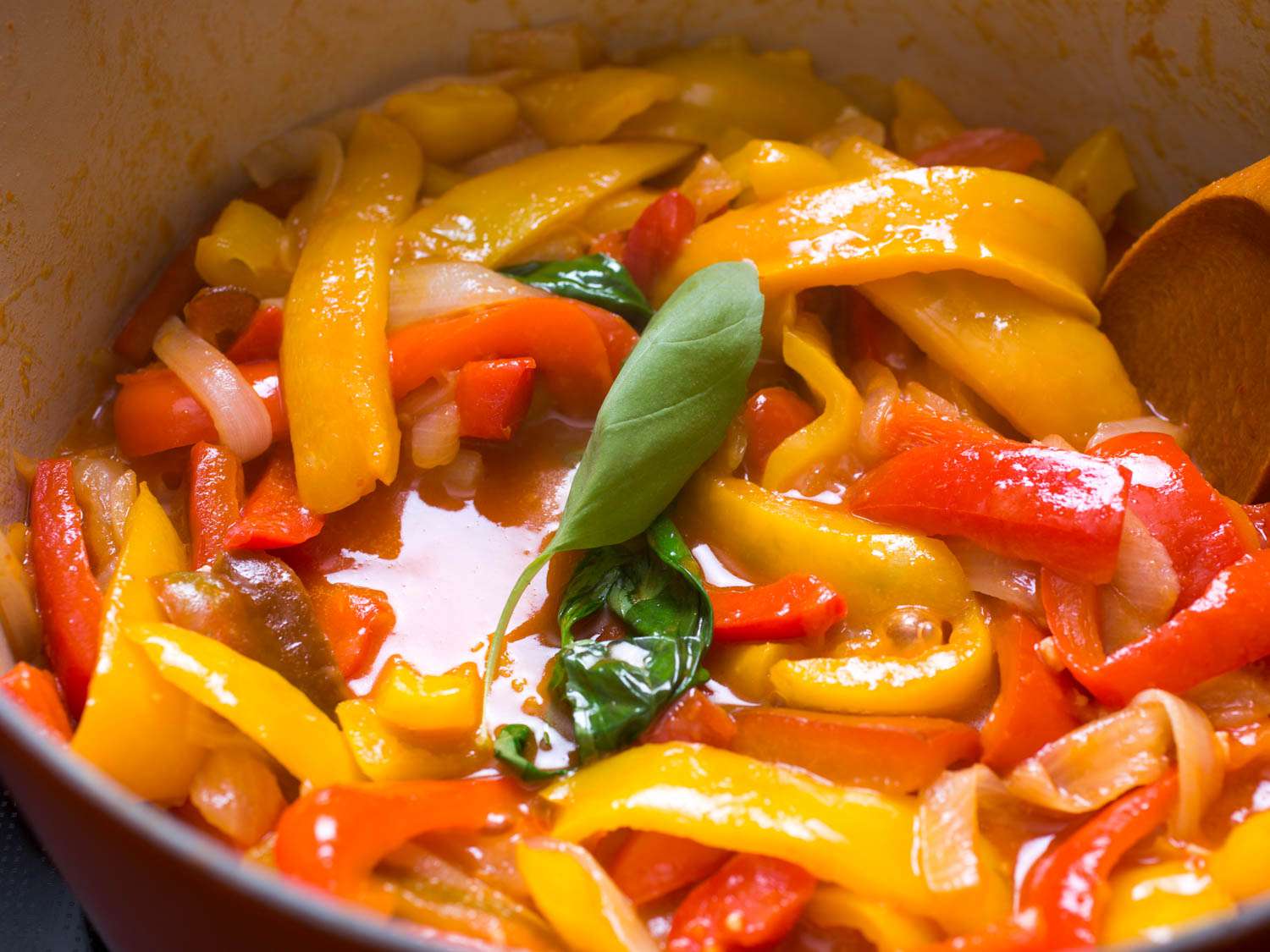 A few leaves of basil thrown in and cooking with the pepper and onion mixture.