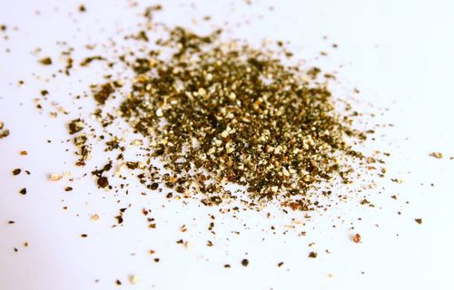 Crushed black pepper on white surface.