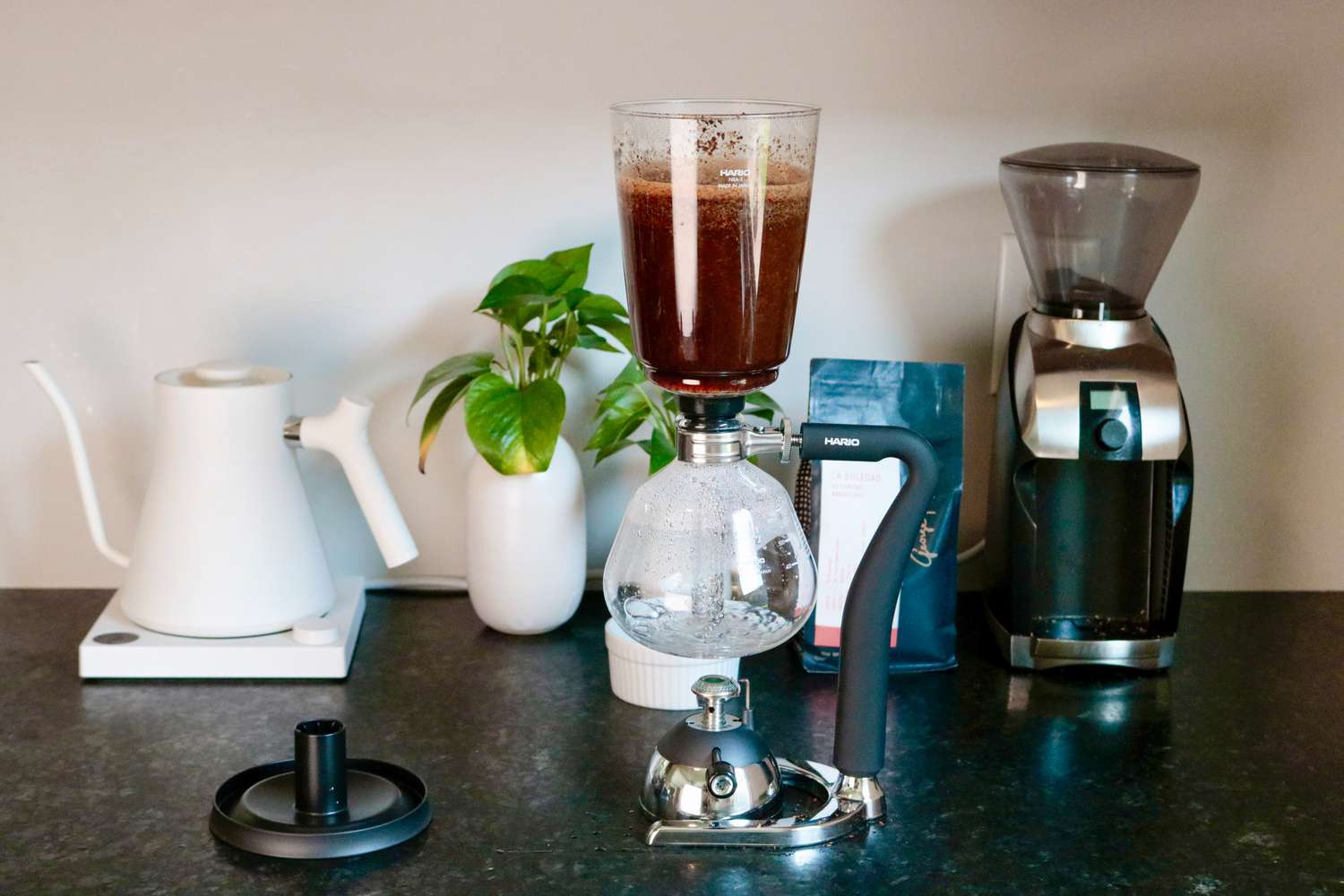 Coffee brewing in a siphon brewer set on a bunsen burner