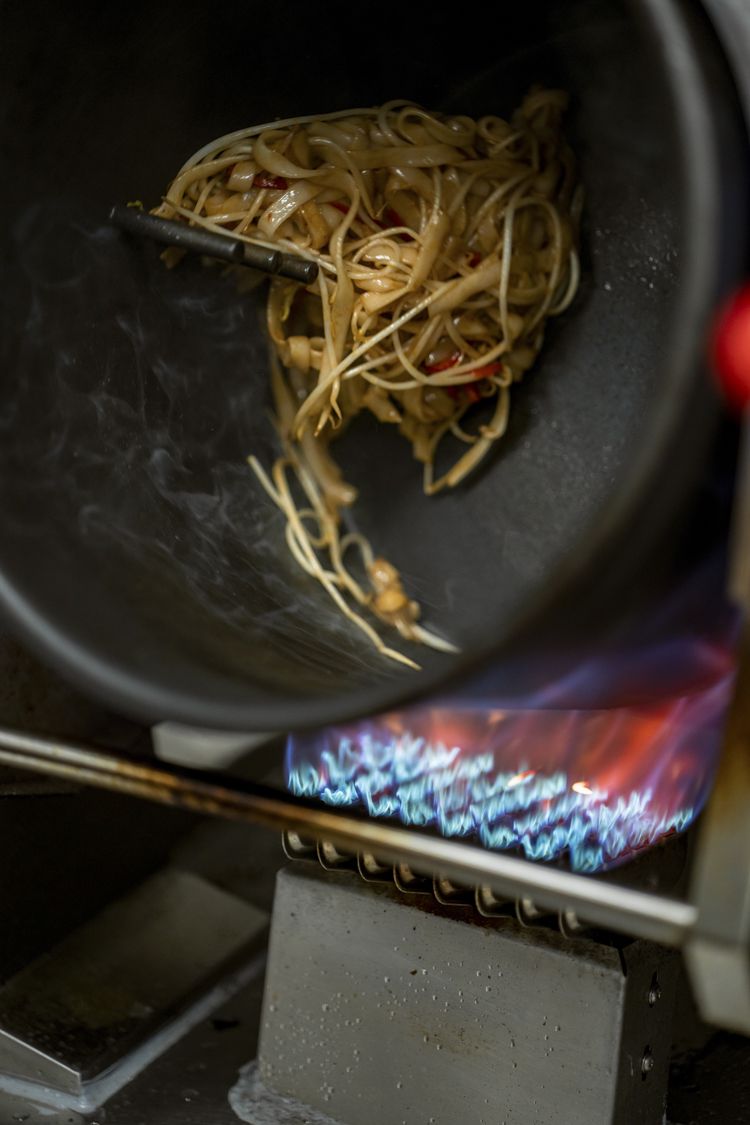 A machine tumbling food to season a surface