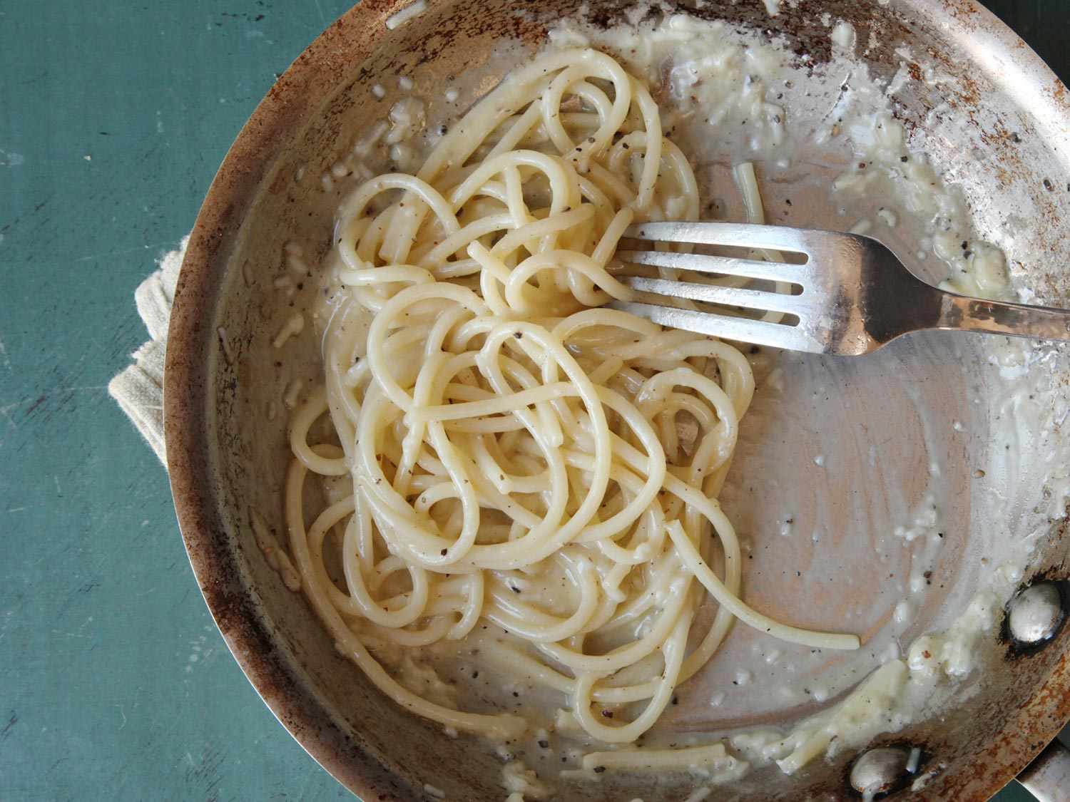 Cacio e pepe shown with a clumpy cheese sauce