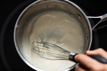 Whisking a homemade mornay sauce in a pan