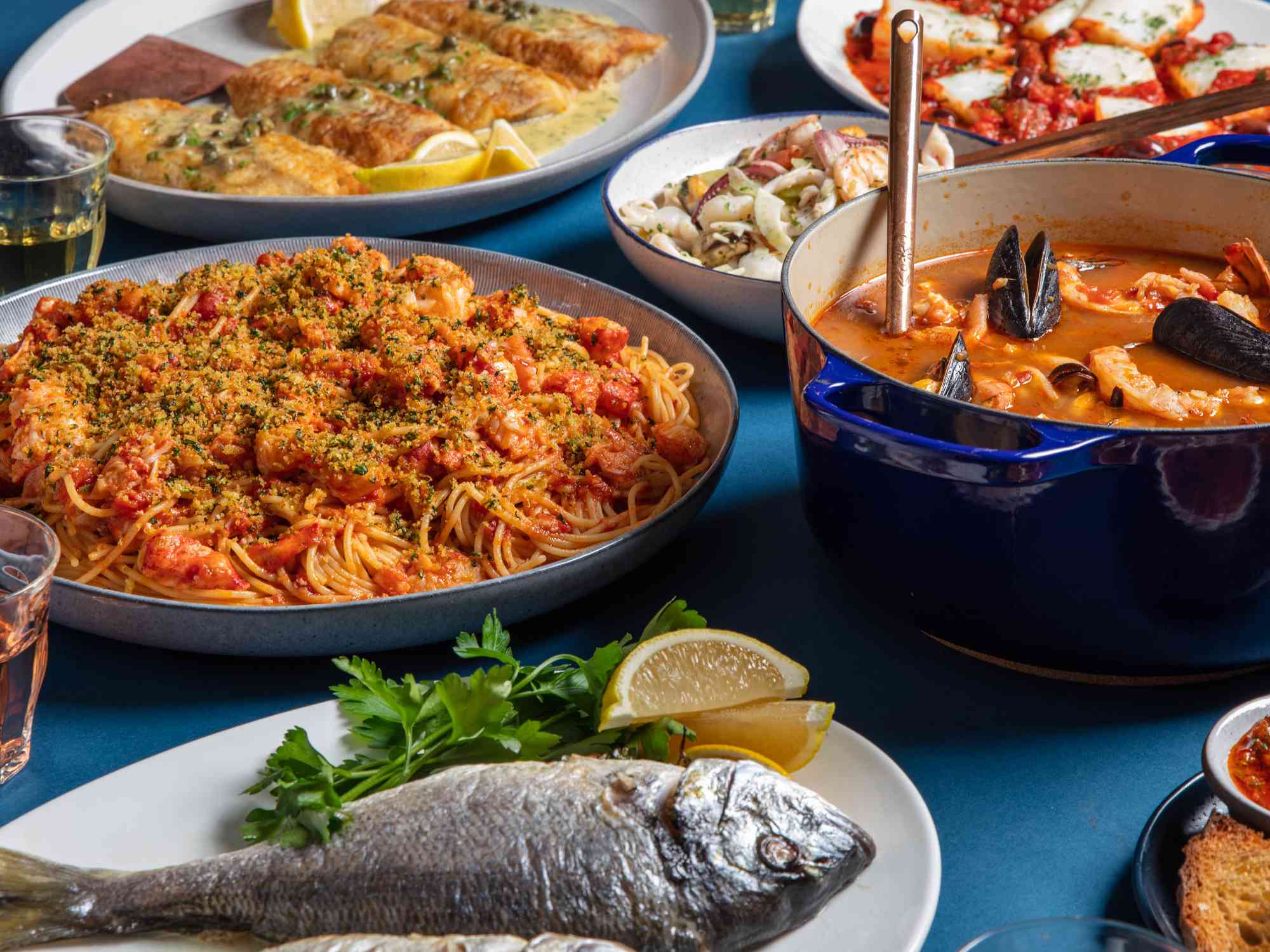 Feast of the Seven Fishes spread on a blue table lining.