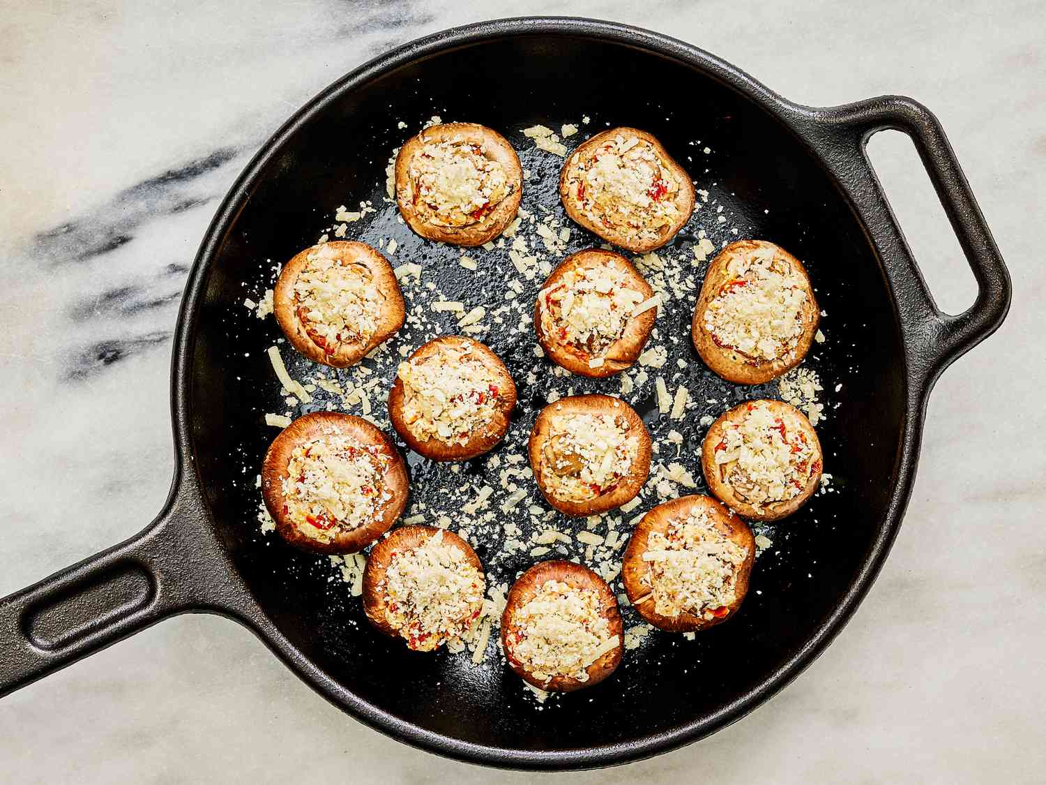 Filled mushrooms cooking in a skillet 