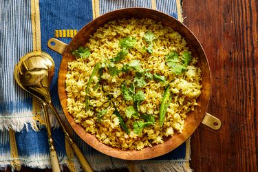 Overhead view of fodni bhaat on a blue and yellow stripped linen