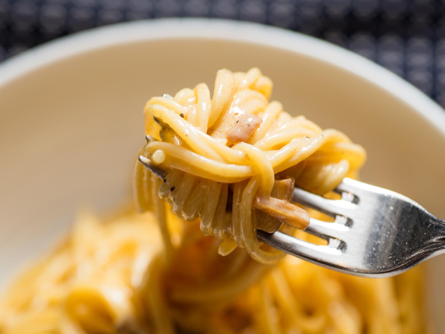 Spaghetti strands being swirled onto a fork. 
