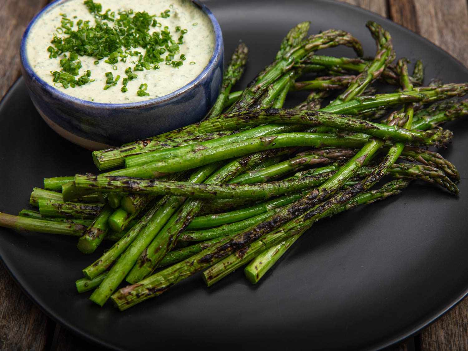 Side view of grilled asparagus with green goddess dipping sauce.