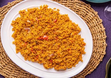 A plate of Nigerian Jollof rice served on a woven mat