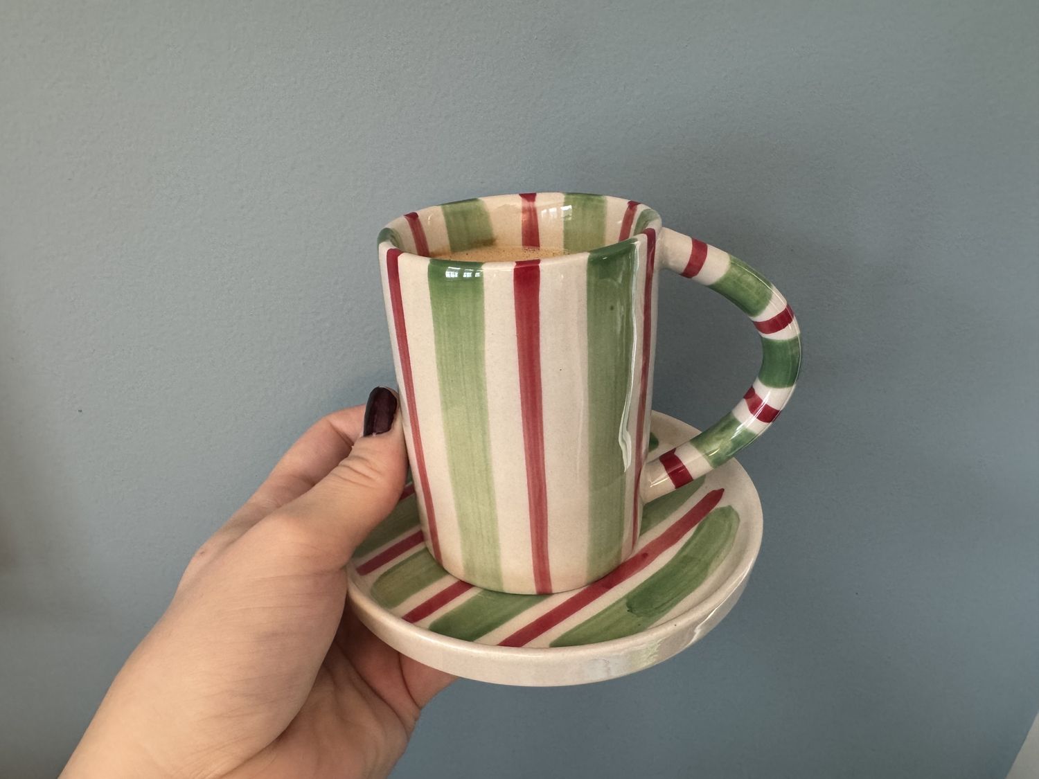 A striped coffee mug on a saucer