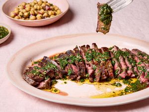 Sliced steak topped with green chermoula served with chickpea salad on the side