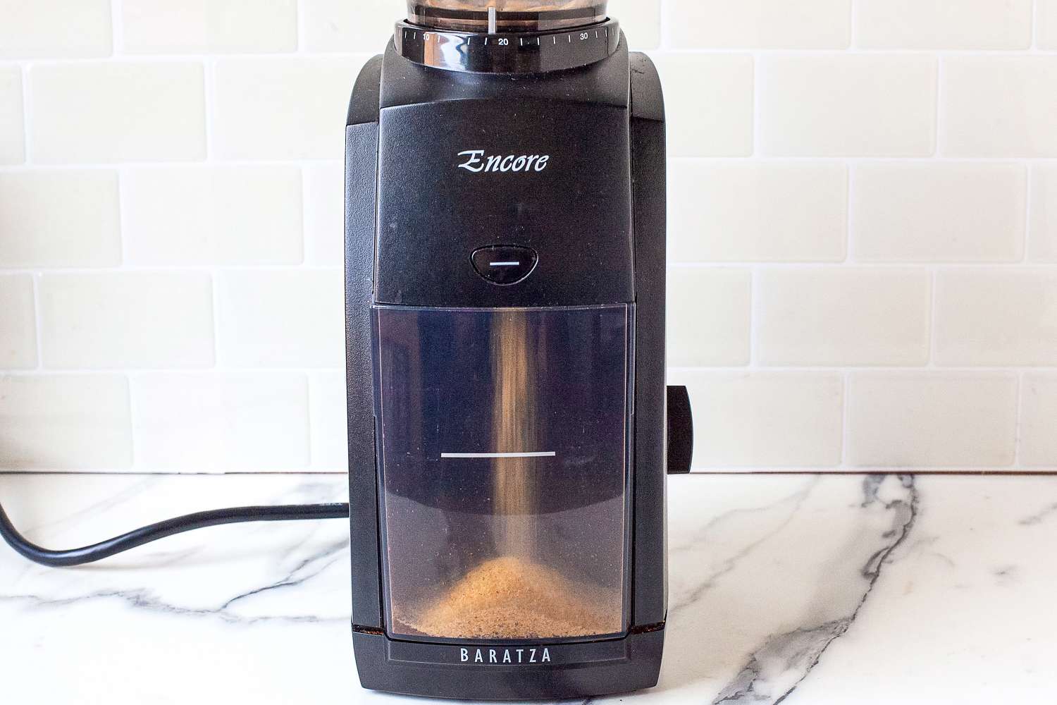 A Baratza Encore coffee grinder dispensing coffee grinder cleaner.