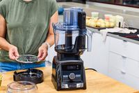 A person assembles the Vitamix 12-Cup Food Processor Attachment
