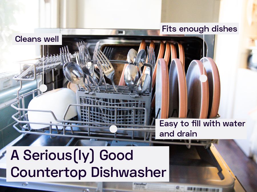 A countertop dishwasher filled with dishes and silverware.