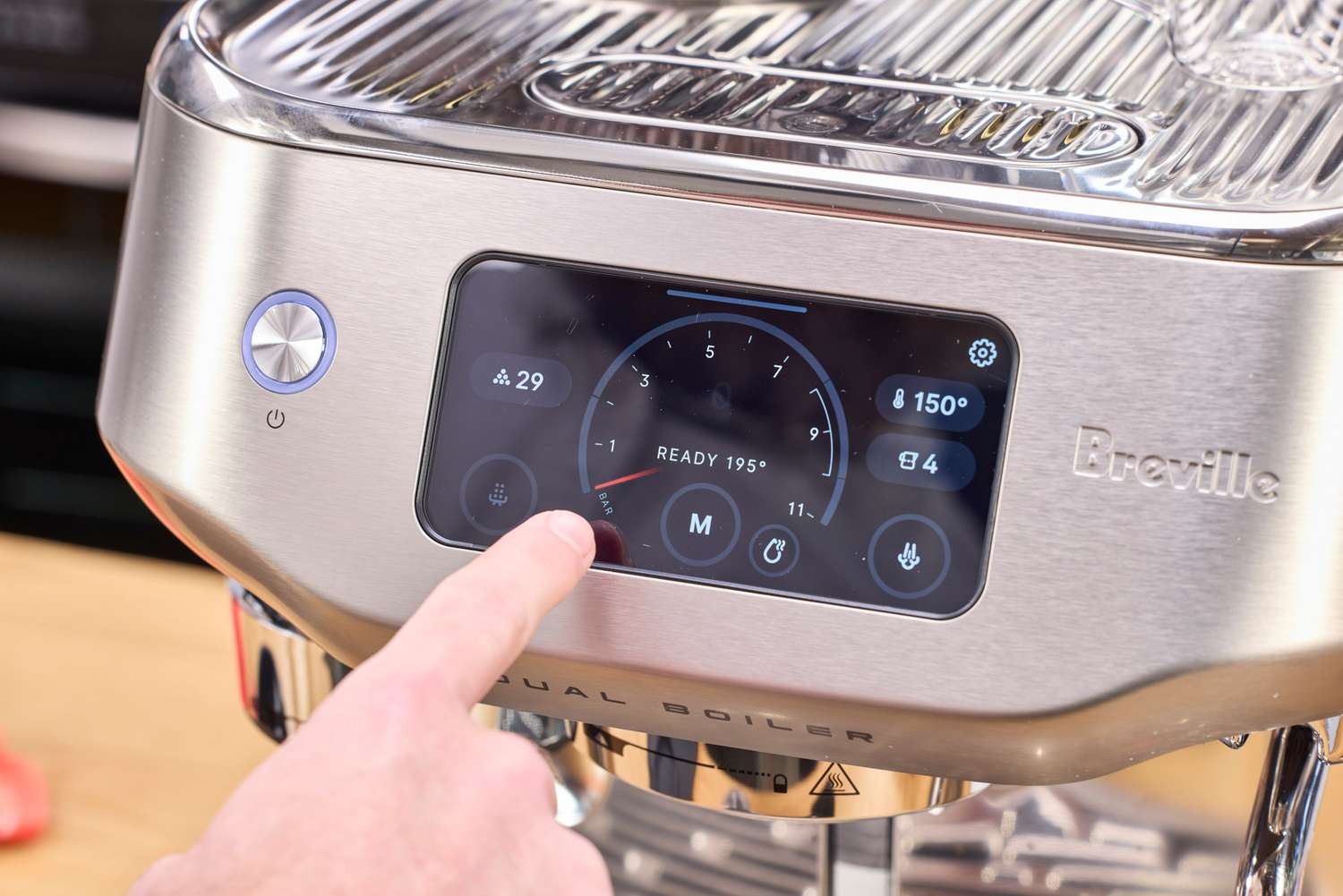 A person presses a button on the Breville The Oracle Dual Boiler Espresso Machine