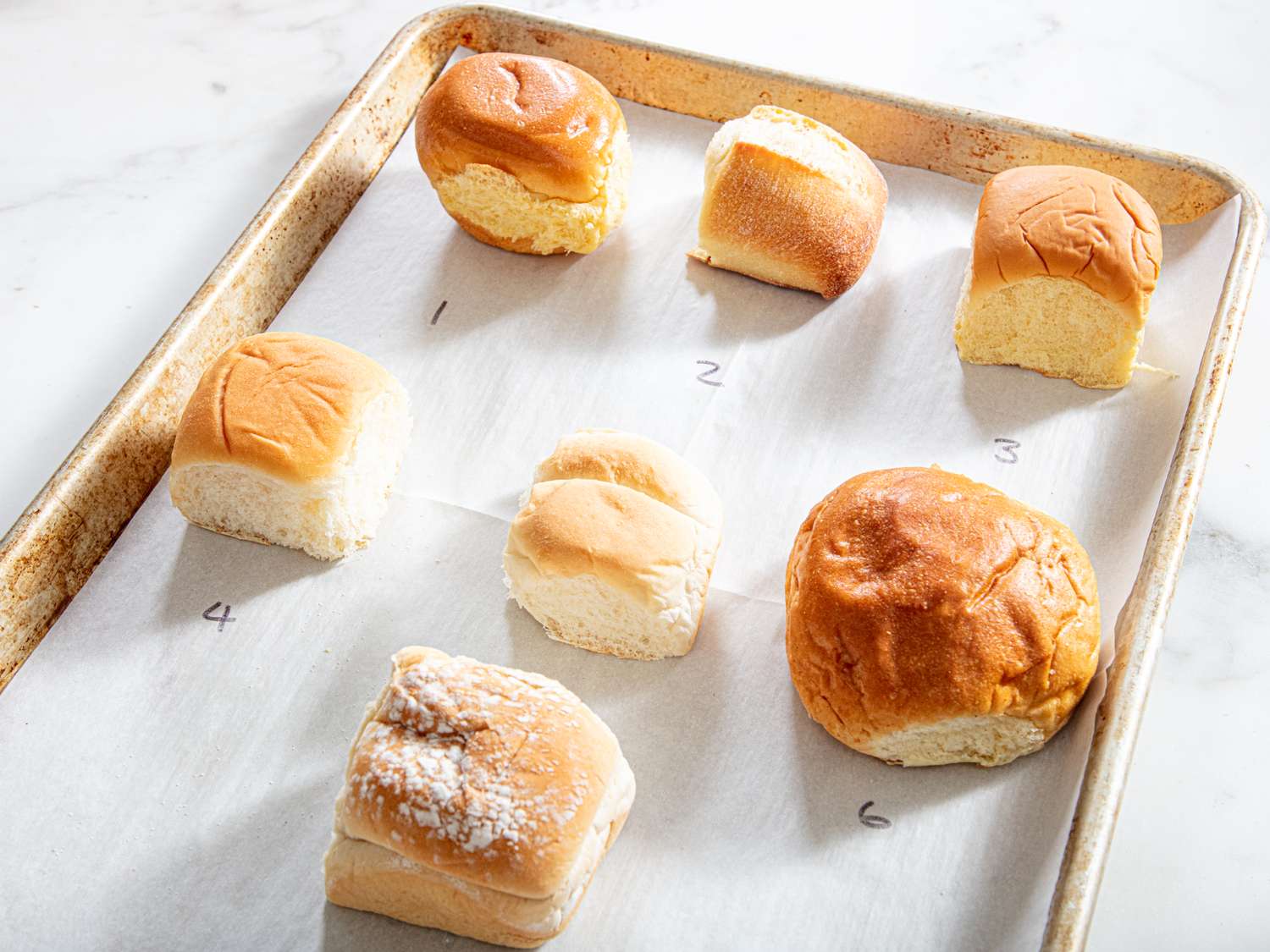 Six dinner rolls on a baking sheet lined with parchment paper numbered 1 to 6