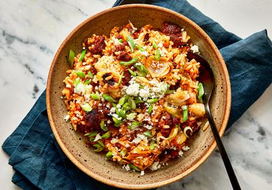 A bowl of Mexicaninspired fried rice topped with garnishes and served on a cloth napkin