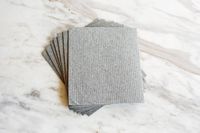 A stack of gray grey Swedish dishcloths on a marble countertop .