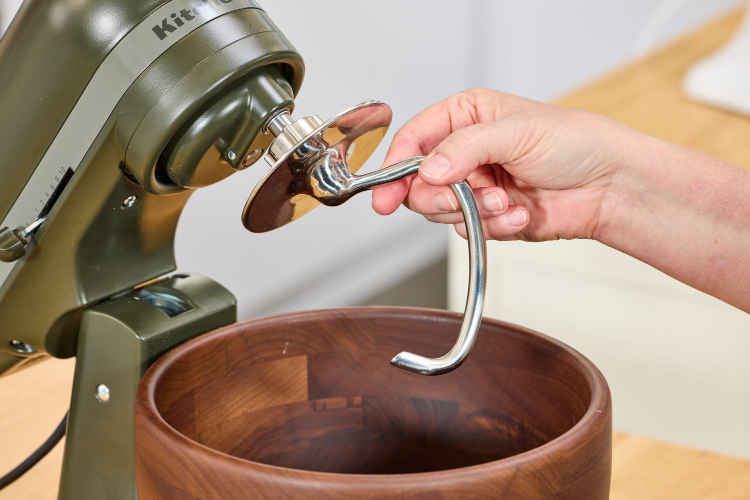 A person attaches the dough hook to the KitchenAid Design Series Evergreen Stand Mixer