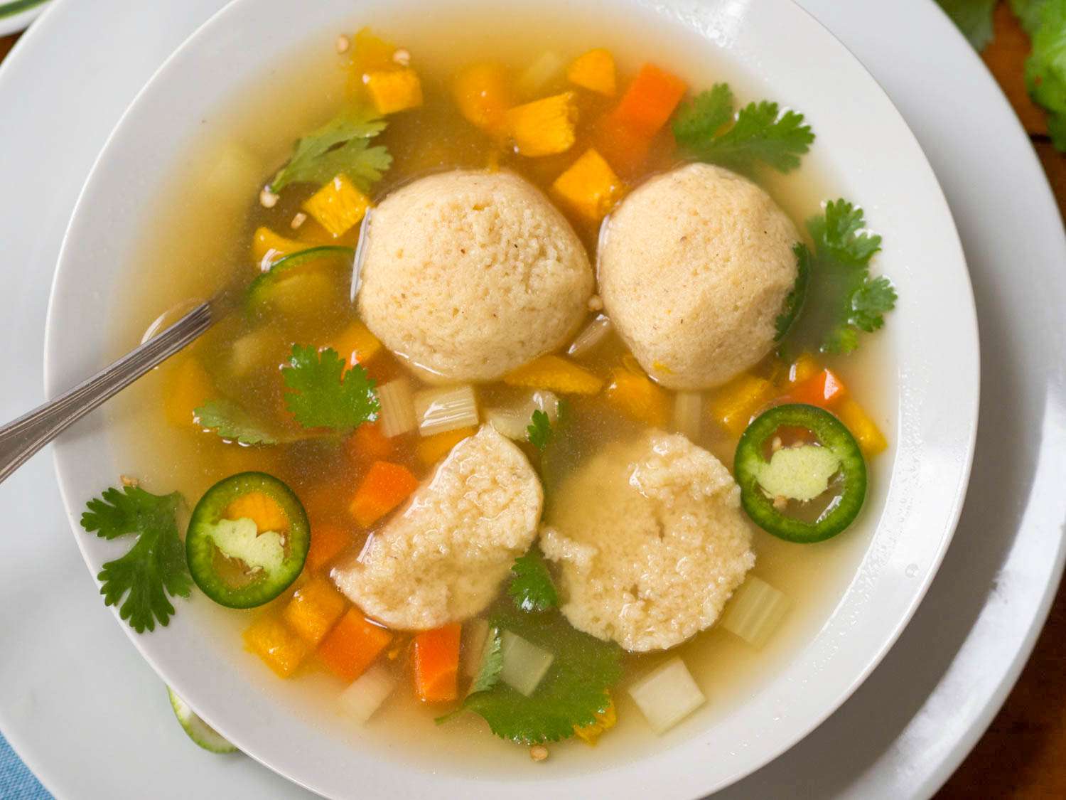 A bowl of masa-ball soup with one of the balls cut in half.