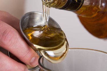 Closeup of bourbon being measured with a jigger.