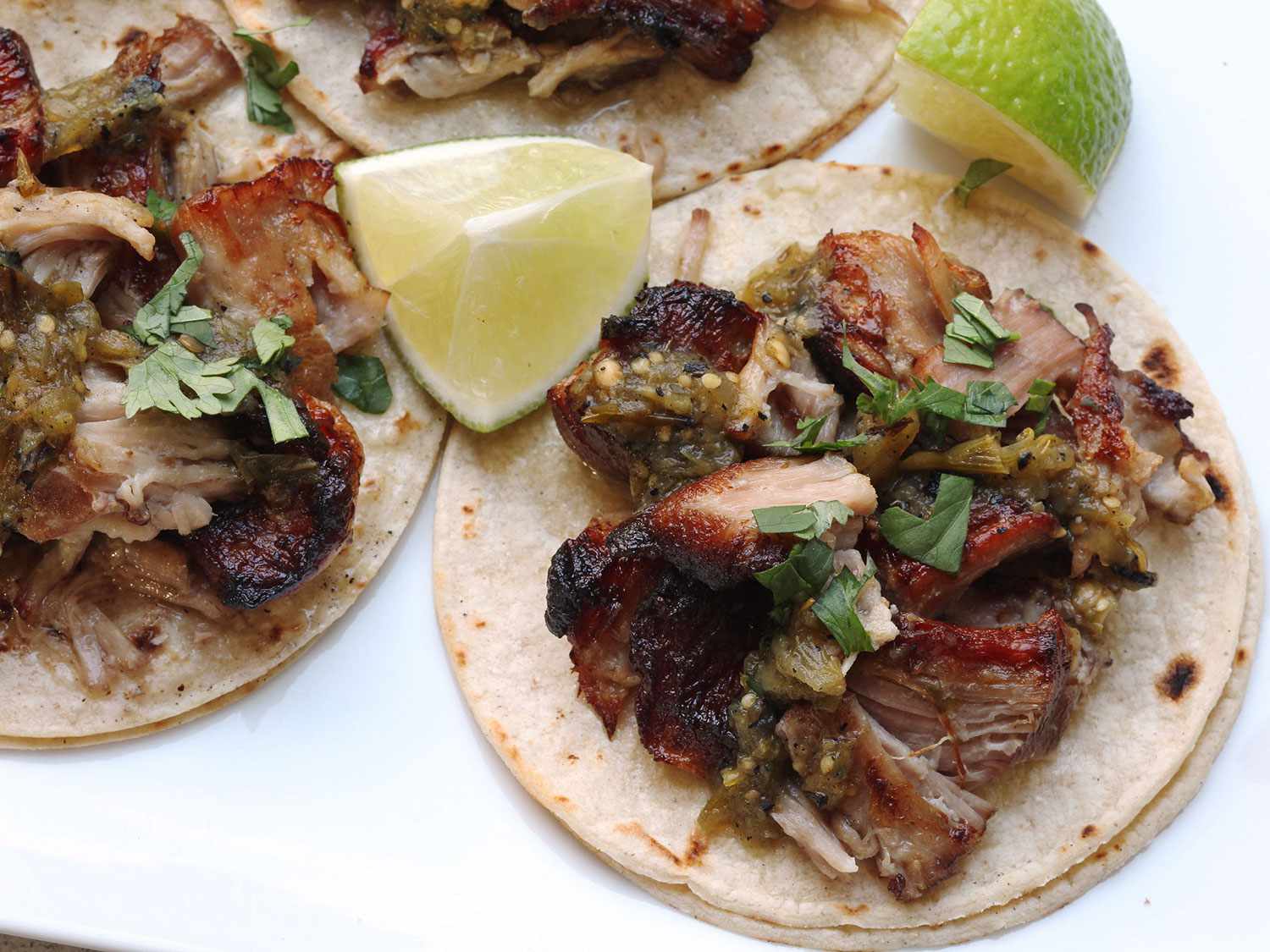 Sous vide carnitas cochinita pibil tacos with lime wedges