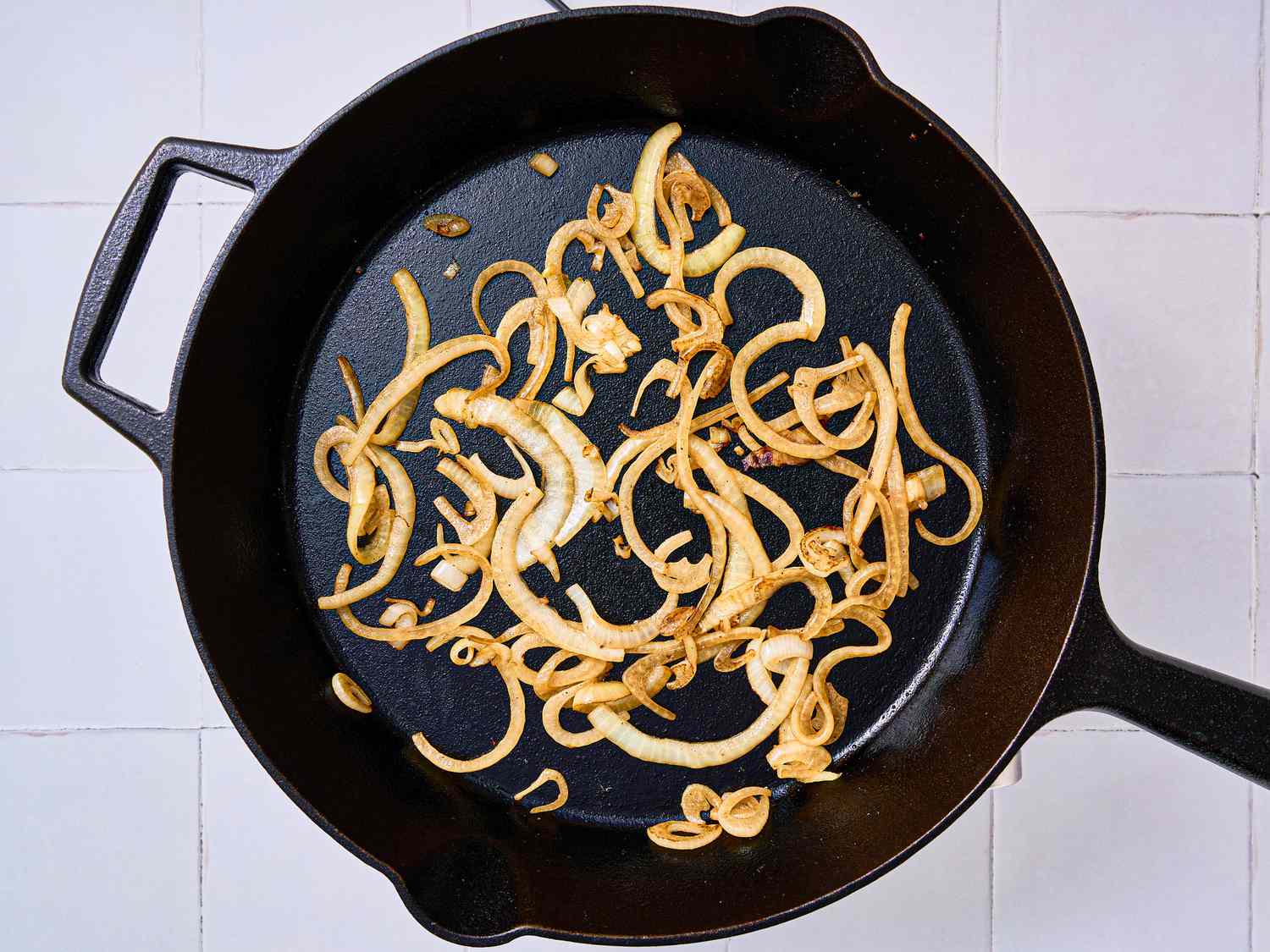 Onions cooking in a cast iron skillet.