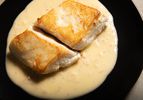 Overhead view of fish plated on top of Beurre Blanc sauce