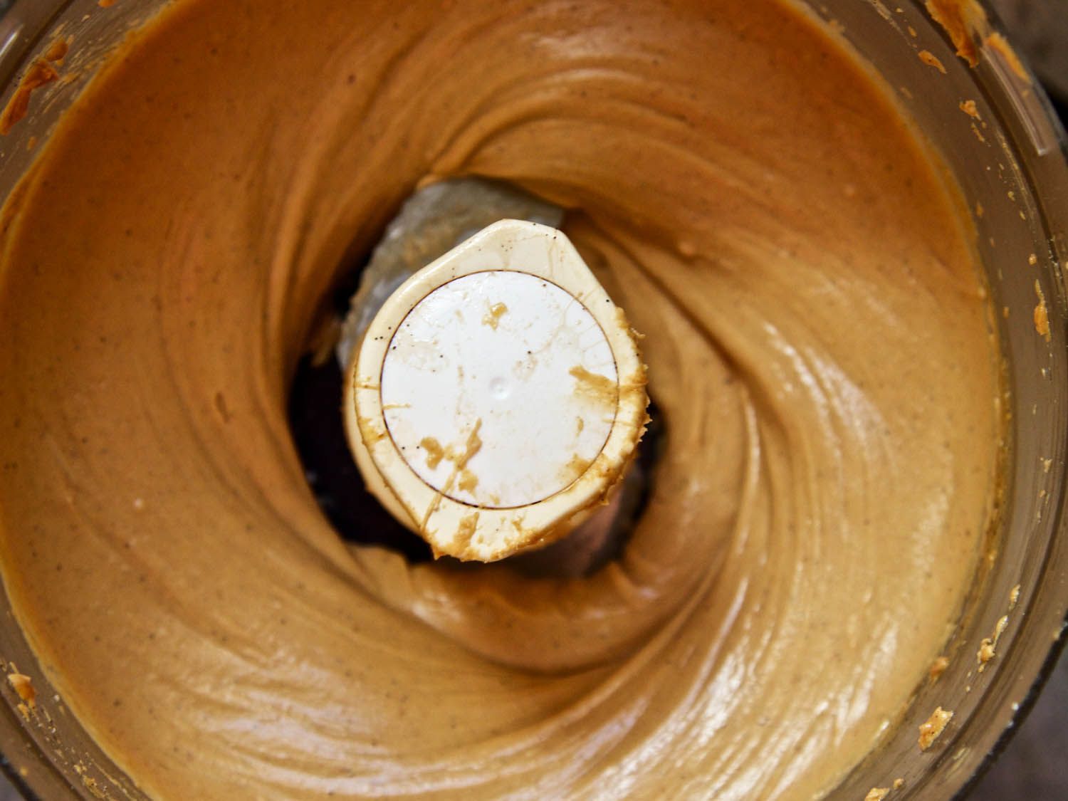 Processing peanut butter and white chocolate in a food processor until smooth.