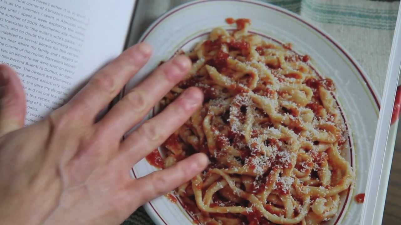 Closeup of a hand touching a page showing pasta from The Glorious Pasta of Italy book