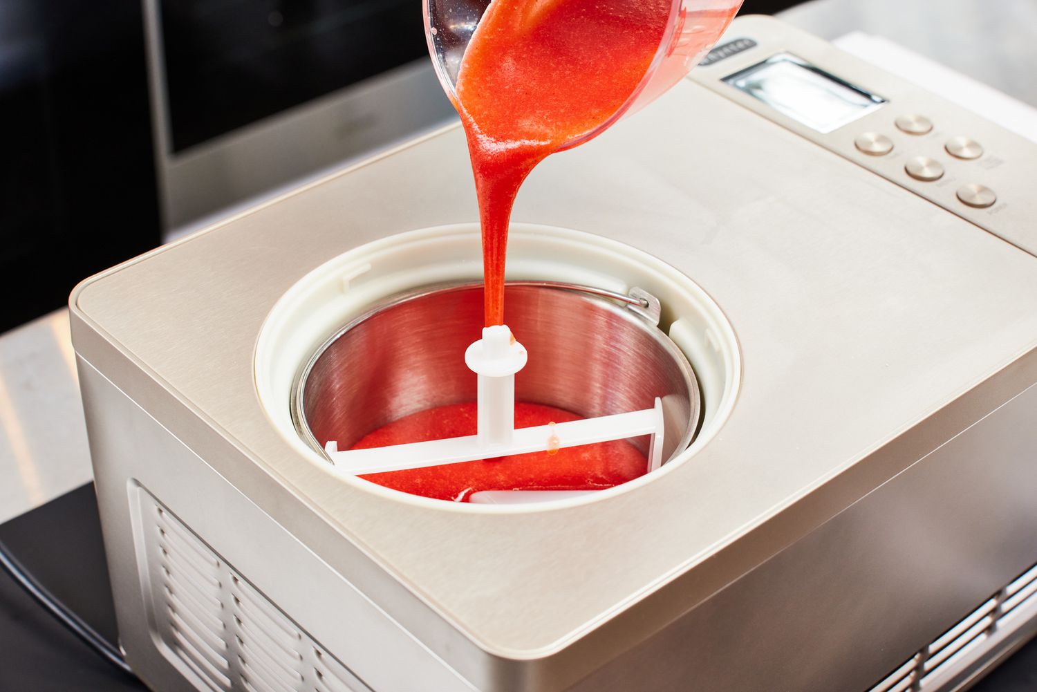 A person pouring sorbet base into the Whynter 2-Quart Ice Cream Maker
