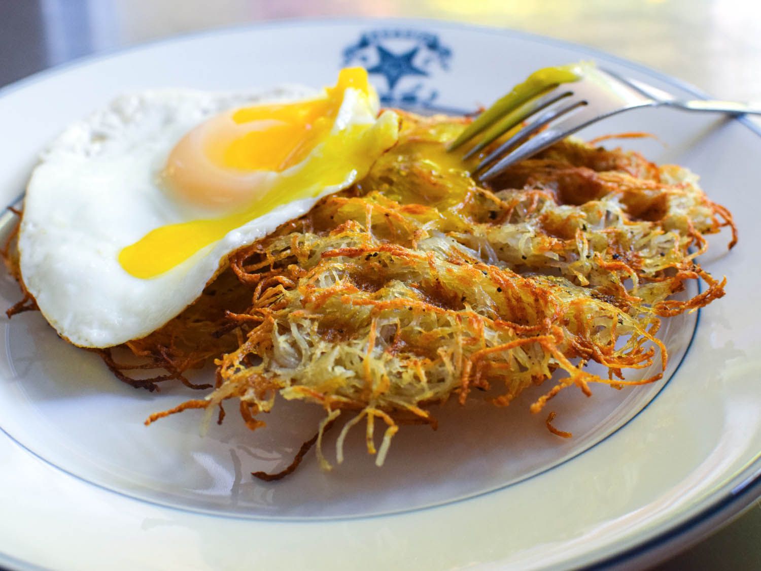 Waffle-Iron Hash Browns with a sunny side up egg on a plate. 