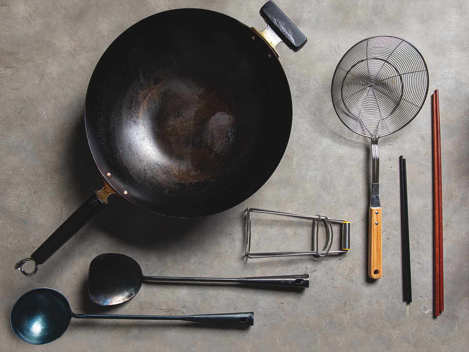 A top-down view of a wok and accessories arranged neatly on a table