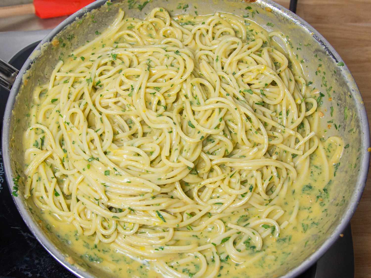 Parsley and lemon juice being added to the pasta bottarga mixture.