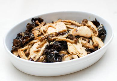 Stir-fried chicken with mushrooms and oyster sauce, served in an oblong white bowl.