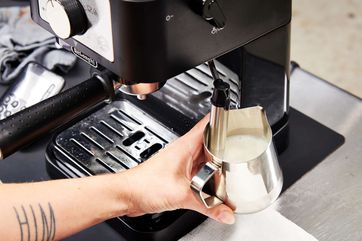 Hand steaming milk using the milk frother of the De'Longhi Stilosa Espresso Machine