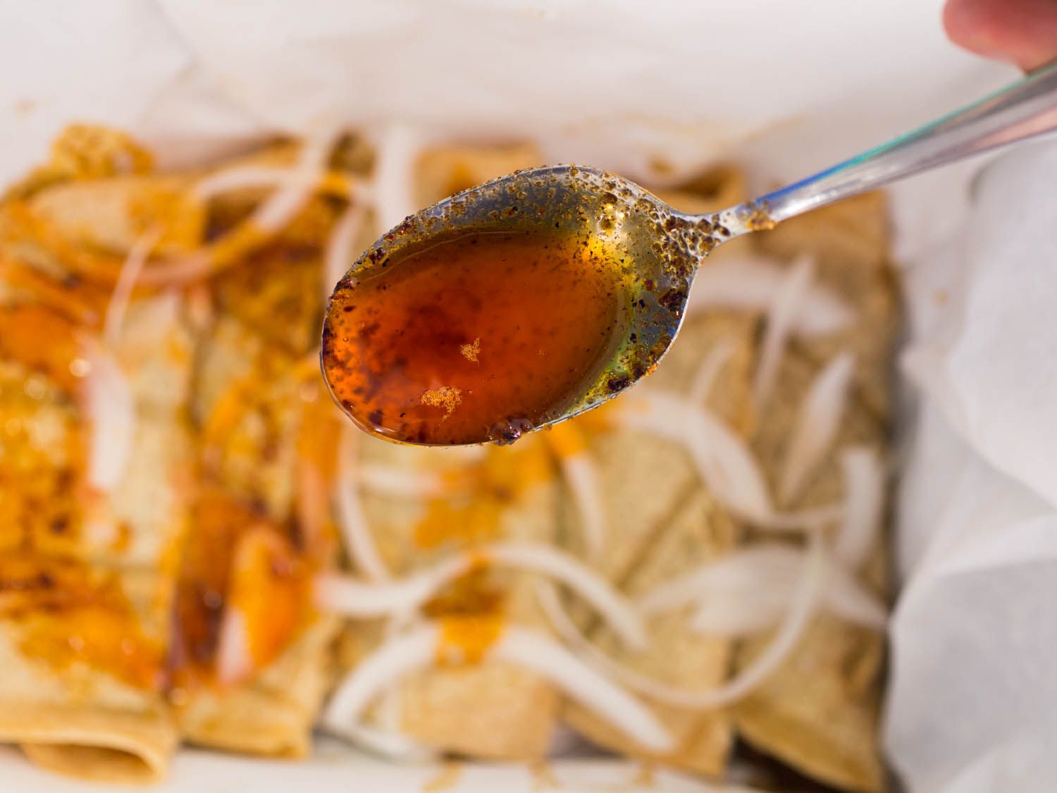 Spooning hot chile oil onto canasta tacos