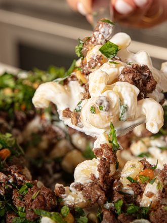 Plate of pasta with ground beef and herbs being served
