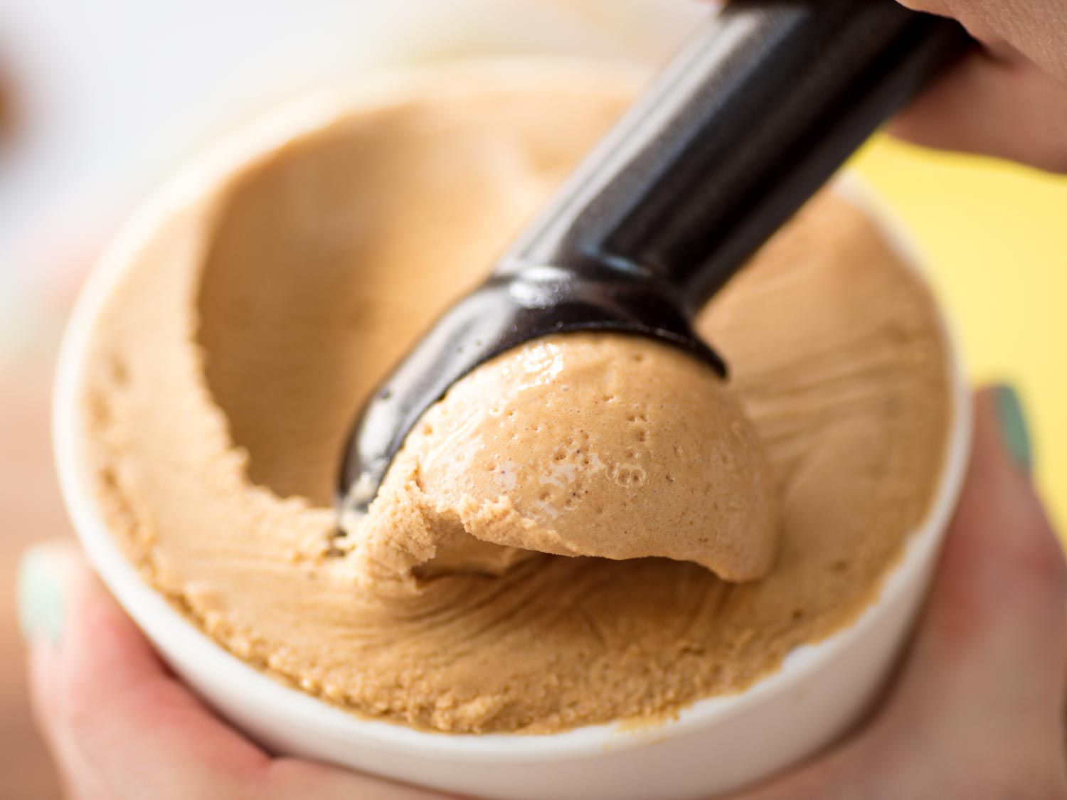 The finished ice cream is scooped from the container.
